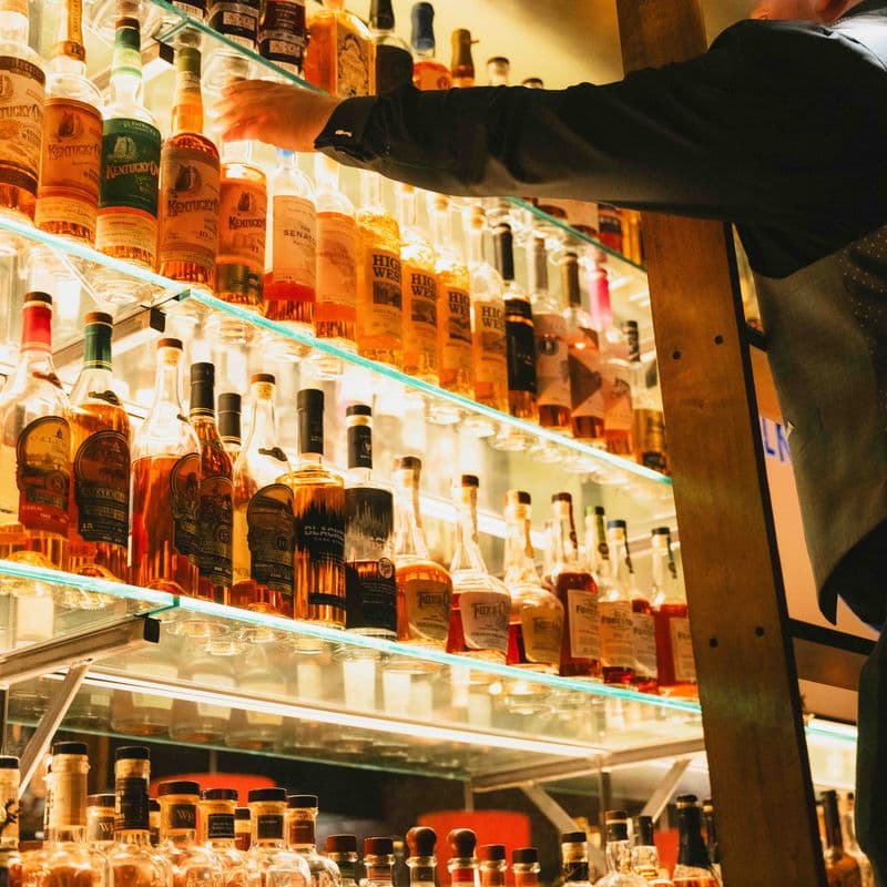 A floor-to-ceiling whiskey wall with a rolling ladder